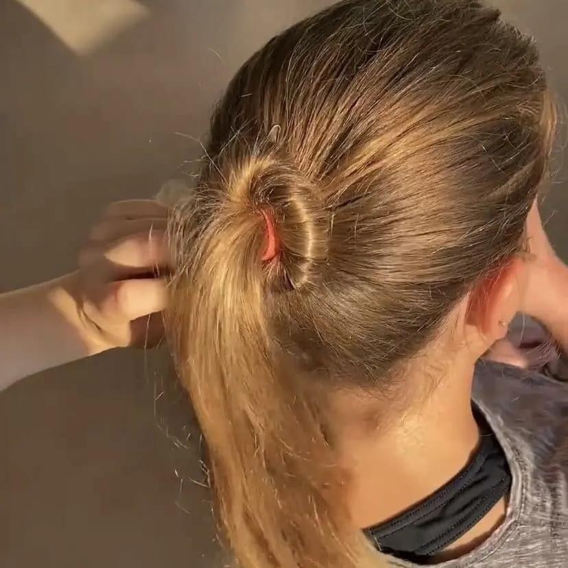 A Cavod ballet dancer with one ponytail section wrapped around the other starting a Ballet Bun