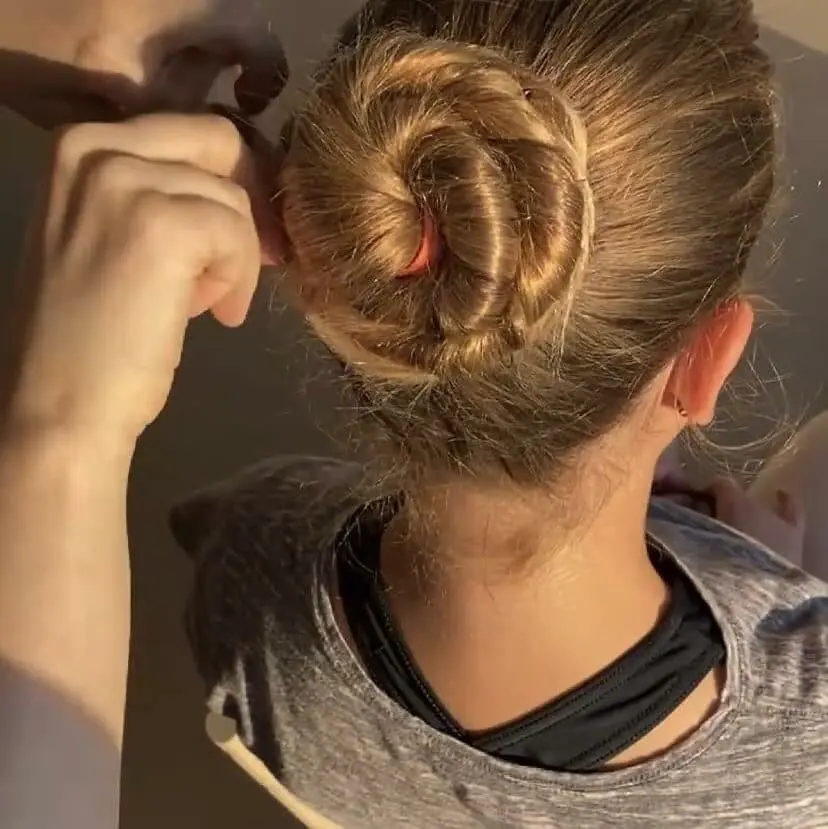 A woman fixing a ballet bun for a ballet dancer before her performance at Cavod Performing Arts