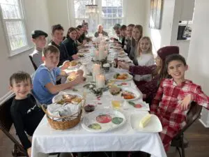 Relatives of a Cavod employee sitting together and smiling at a long dinner table on Christmas Eve.