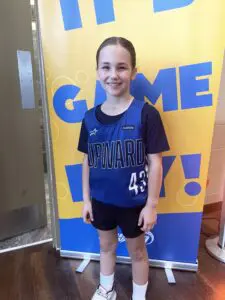 A smiling girl getting ready to play basketball. 