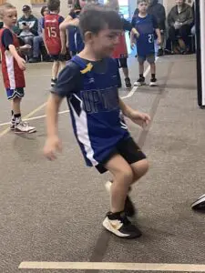 A boy in a sports uniform running drills.