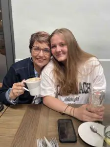 Cavod Academy Executive Director Connie Dienner sitting with a young girl. 