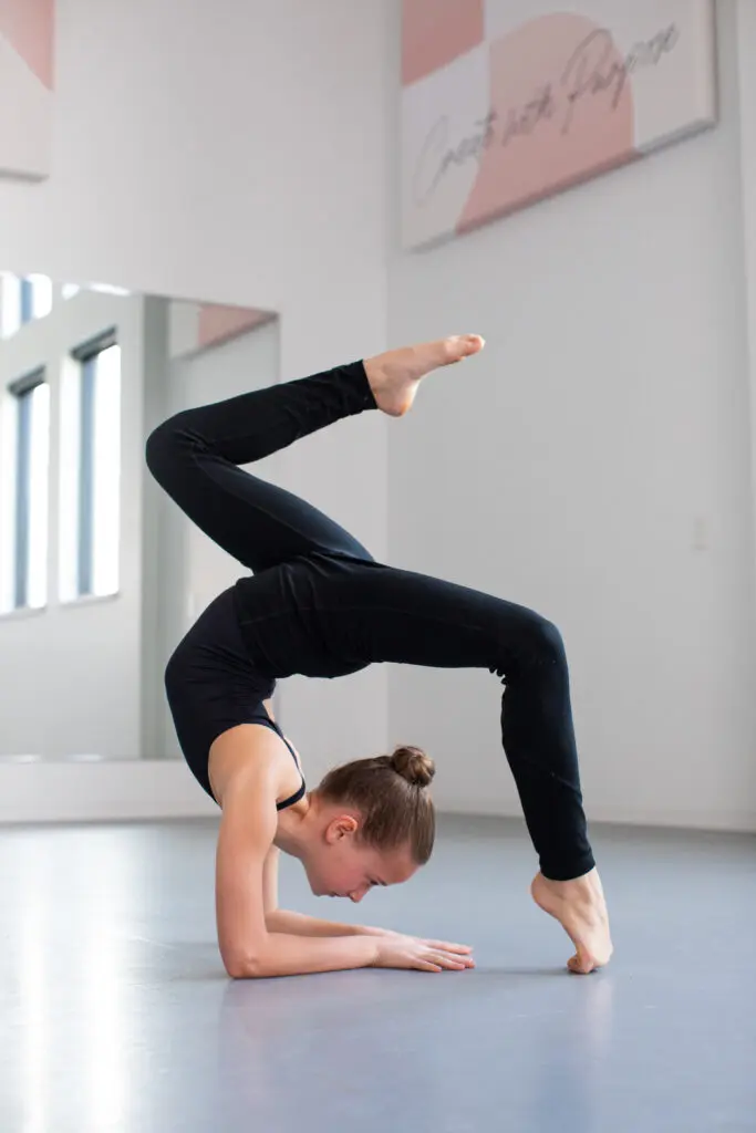 A girl in a dancing leotard doing a flexed handstand at Cavod Performing Arts dance studio.