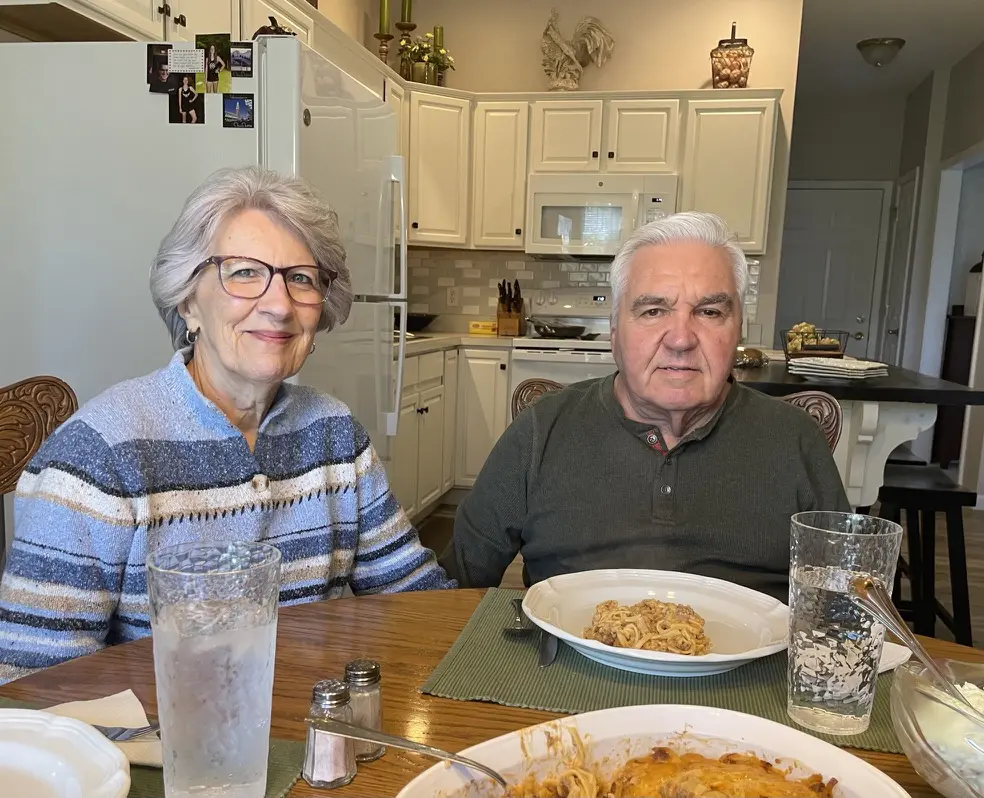 A picture of two adults smiling while eating dinner with Cavod's Executive Director Connie Dienner