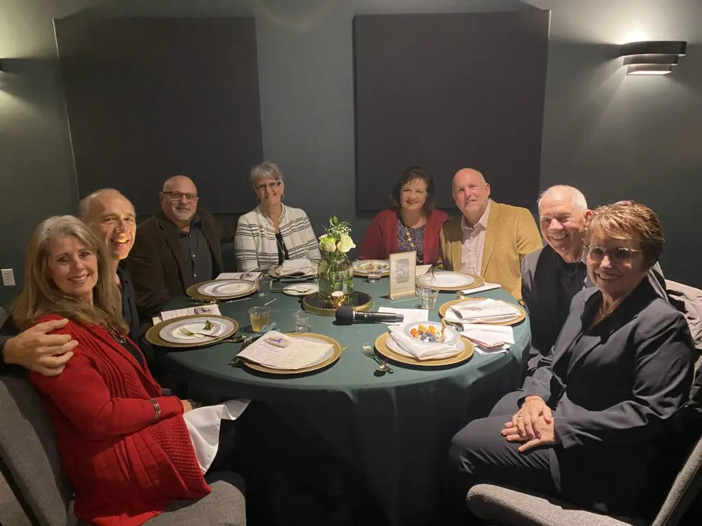 Cavod's Executive Director Connie Dienner sitting with friends at the December 2023 dinner theatre.