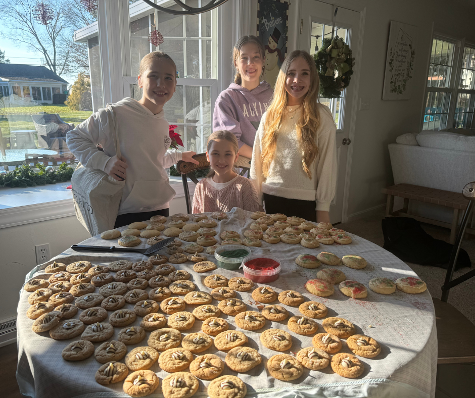 Young girls smiling for a picture while making homemade cookies