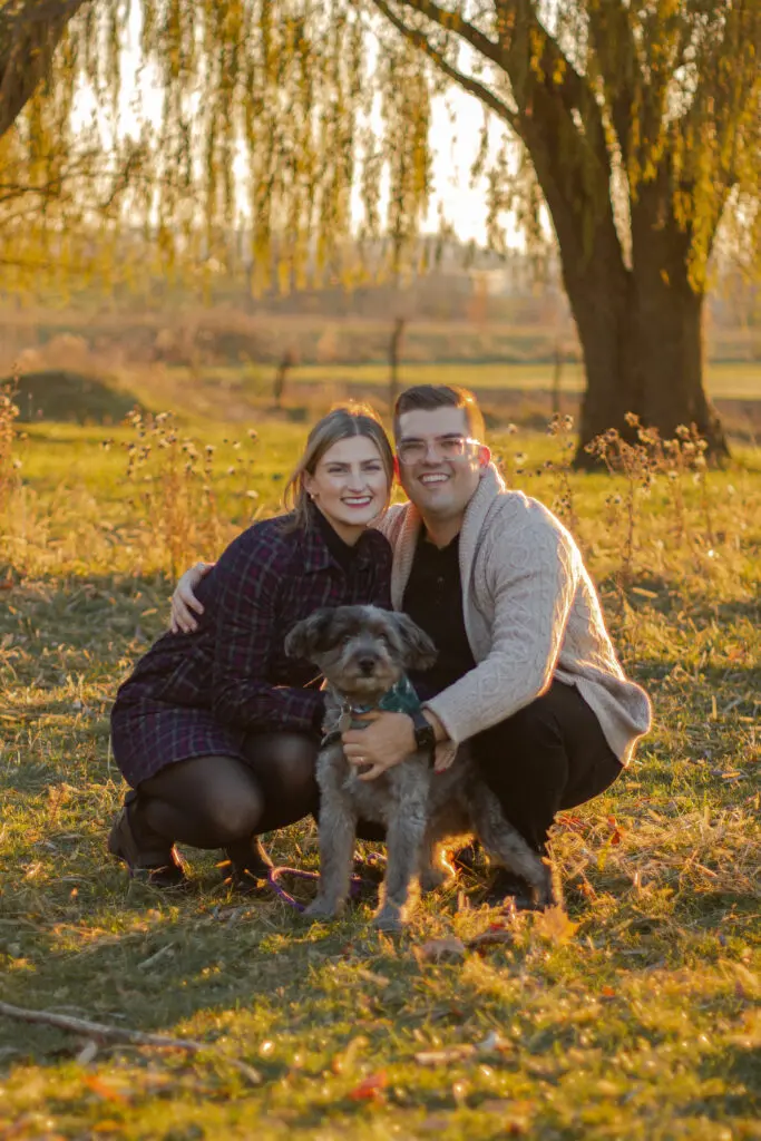 Connie Dienner's son and his wife posing with their dog for a photo