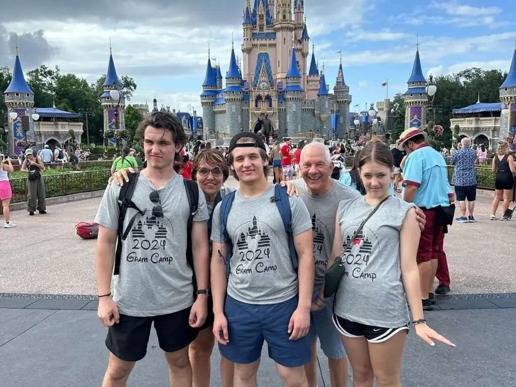 Cavod's Connie Dienner and her husband posing for a picture in Disney with their grand children all grown up