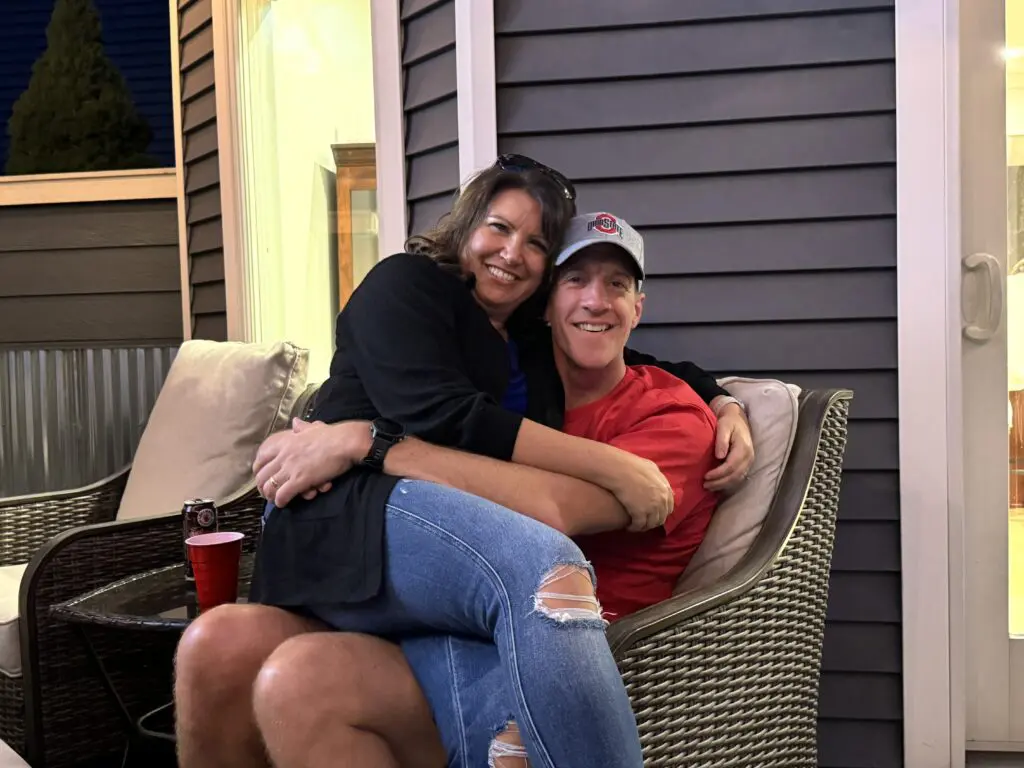 Couple seated outdoors, smiling and enjoying each other’s company.