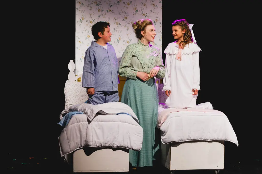 Sophia Grado as Mary Poppins smiling alongside children from the cast, creating a magical moment on stage in Lancaster, PA