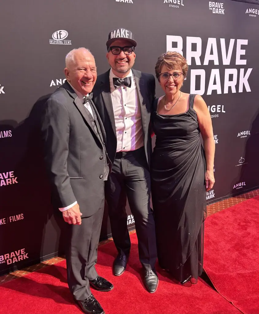 Derek Stoltzfus smiling with his proud parents, Connie and Dave, at the premiere of "Brave the Dark."