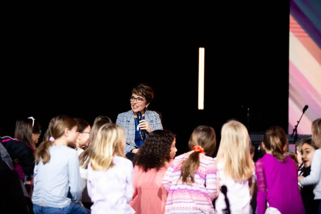 Connie warmly interacting with a group of children, sharing wisdom and encouragement at Cavod’s 20th-anniversary event.