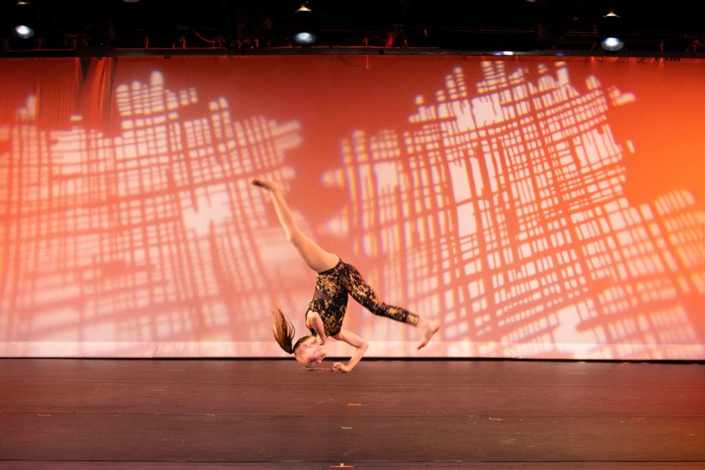An Acrobatic Arts student performing a whirling handstand on stage at Cavod | Cavod Performing Arts