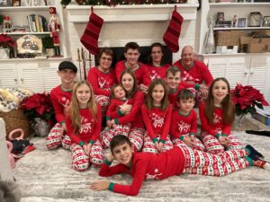 Cavod's executive director Connie Dienner and her family sitting around the fireplace in matching Christmas pajamas. 