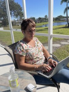 Cavod Academy's Executive Director Connie Dienner working outside in a lawn chair.