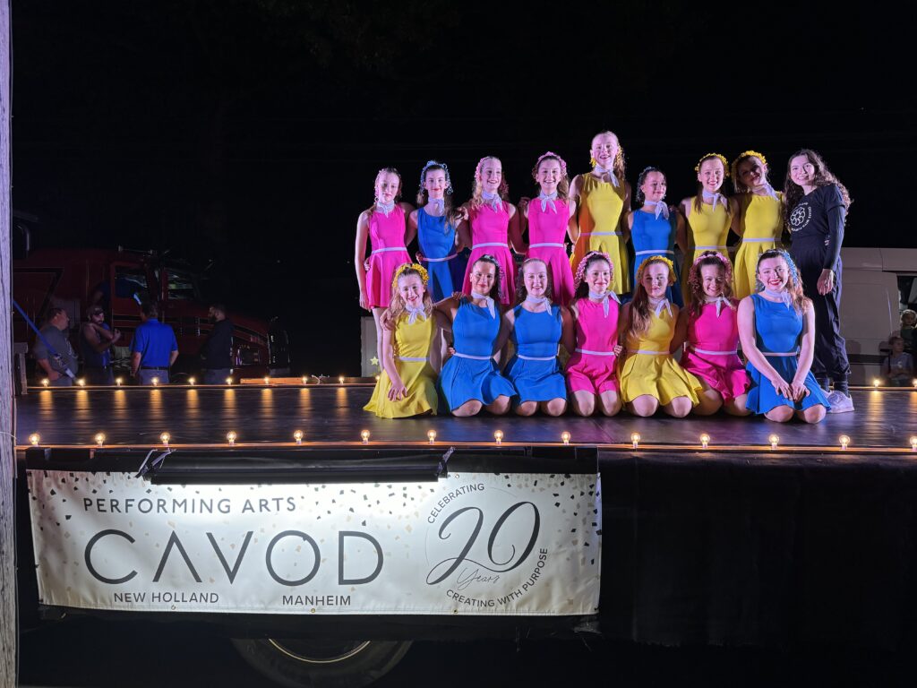 Young dancers on Cavod's anniversary float wearing bright costumes to celebrate 20 years.