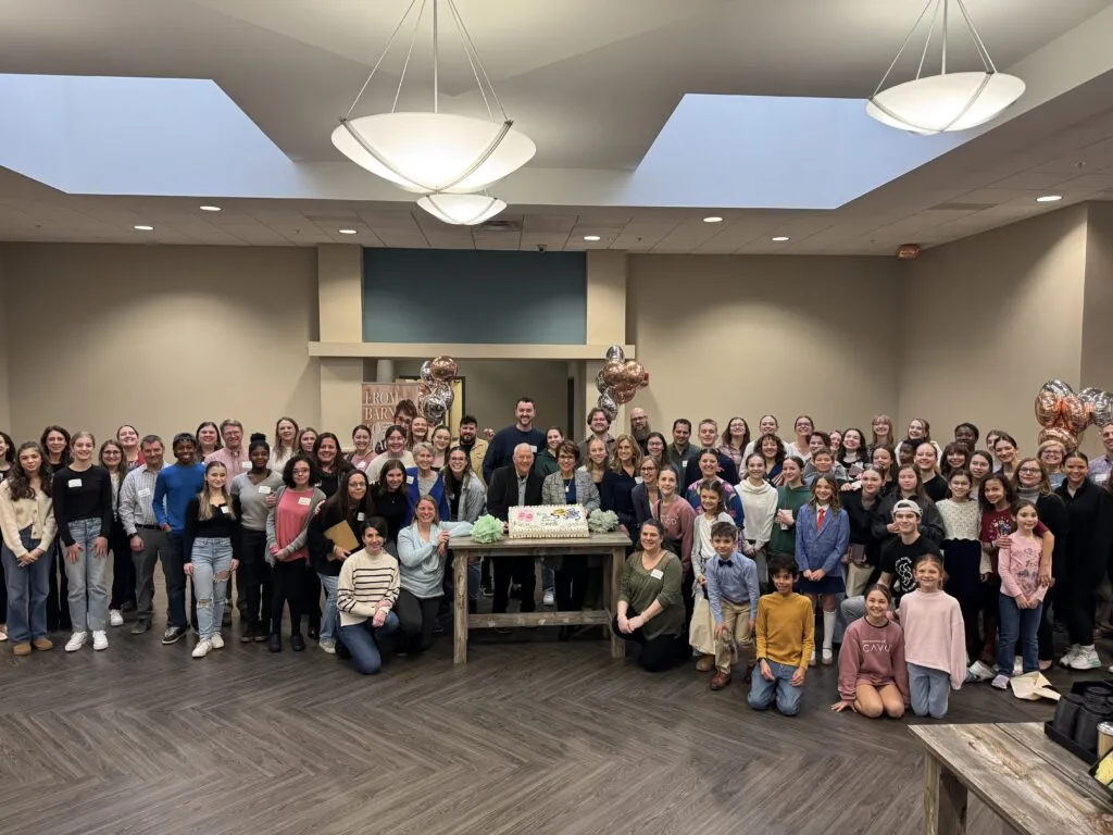 A joyful group of 130 volunteers and performers gathered around the 20th-anniversary cake at Cavod Performing Arts